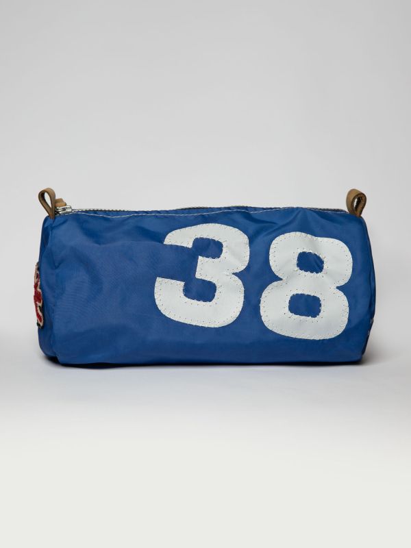 This blue handmade sailcloth washbag was individually made. Each unique bag was pieced together by hand, with our special appliquéd sail-stitched numbers. Made from genuine nylon sailcloth, this washbag is durable and and easy to clean, making it the perf